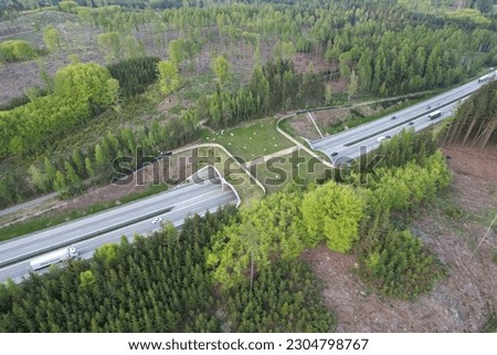 Aerial panorama view of ecoduct or wildlife crossing - vegetation covered bridge over a motorway that allows wildlife to safely cross over,wildlife crossing over busy highway,animal overpass Royalty-Free Stock Photo #2304798767