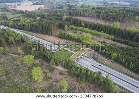 Aerial panorama view of ecoduct or wildlife crossing - vegetation covered bridge over a motorway that allows wildlife to safely cross over,wildlife crossing over busy highway,animal overpass Royalty-Free Stock Photo #2304798769