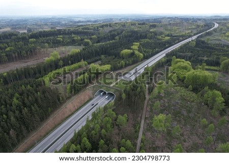 Aerial panorama view of ecoduct or wildlife crossing - vegetation covered bridge over a motorway that allows wildlife to safely cross over,wildlife crossing over busy highway,animal overpass Royalty-Free Stock Photo #2304798773