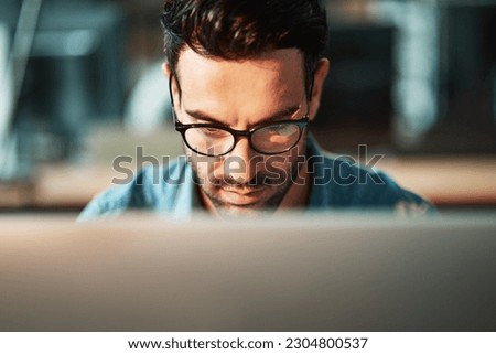 Serious man, face and glasses at computer in office for planning software update, online research and data analysis. Focused developer, desktop and internet connection for business, website or coding
