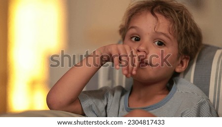 Child boy face watching TV on sofa at night before bed