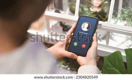 Woman holding mobile phone with incoming call from unknown caller. scammer or stranger, Hoax person with fake identity, Prank caller, anonymous, smartphone, Fraud or phishing concept, Royalty-Free Stock Photo #2304820549