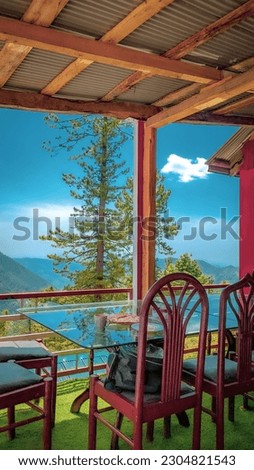 tale and chairs of a restaurant with a beautiful views of the mountains valley