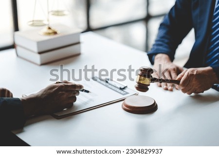 concept of justice and law A male judge in the courtroom on a wooden table and a male counselor or lawyer working in the office. Law, advice and justice concepts.