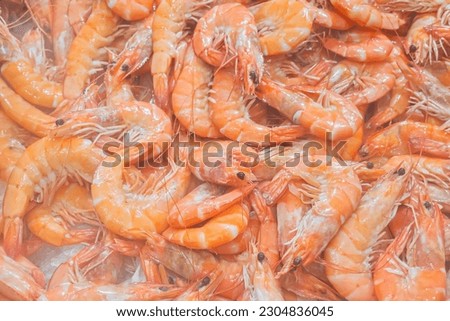 A close up shot showing a display of fresh, loose shrimp on ice for sale in a supermarket