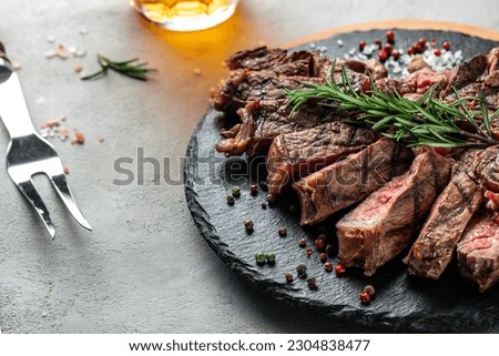 T-bone or porterhouse grilled beef steak with spices and herbs. Long banner format. top view. Royalty-Free Stock Photo #2304838477