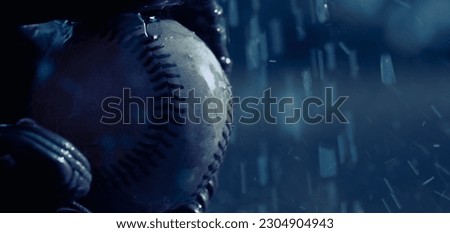 Rain game night concept with baseball in glove in blue color with copy space on background.