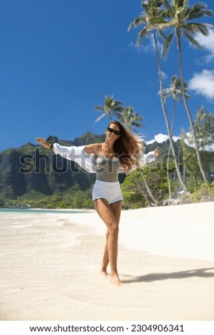 Woman happy walking and running on a beach in paradise Hawaii