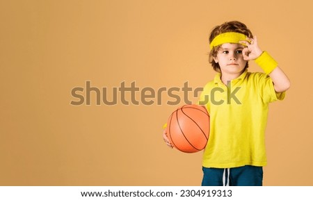 Sport lifestyle. Sporty boy with basketball ball showing sign ok. Sport equipment. Cute child in sportswear with basketball ball. Little basketballer with excellent symbol. Basketball training game.