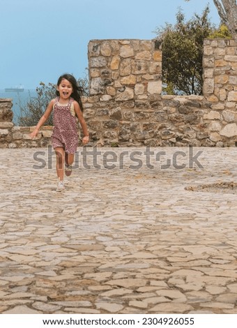 girl posing in the old fortress, girl in a natural pose in a stone fortress, looking at the camera, smiling and moving