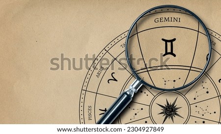 The imprint of the zodiac sign Gemini on old paper is enlarged with a lens Royalty-Free Stock Photo #2304927849