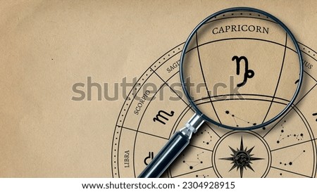 The imprint of the zodiac sign Capricorn on old paper is enlarged with a lens