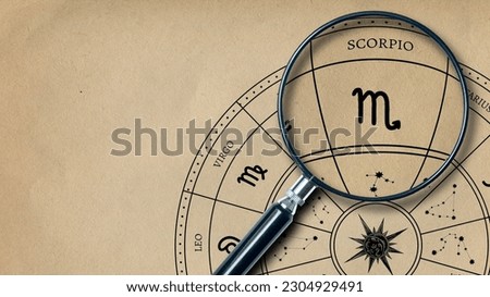 The imprint of the zodiac sign on Scorpio old paper is enlarged with a lens Royalty-Free Stock Photo #2304929491