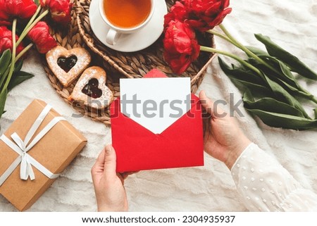 Woman's hands holding a letter in craft envelope. Mother's Day or Valentine's Day concept. Place for your text.