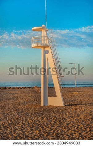 El Campello Spain beach boardwalk promenade sunrise golden hour lifeguard station and striped bathing cabins change room