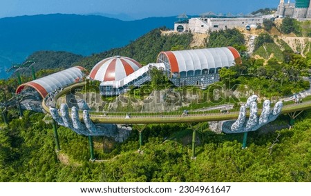 Aerial view of the Golden Bridge in Ba Na hills, Da Nang, Vietnam. Lifted by two giant concrete hands. Iconic world famous bridge in the mountains Royalty-Free Stock Photo #2304961647
