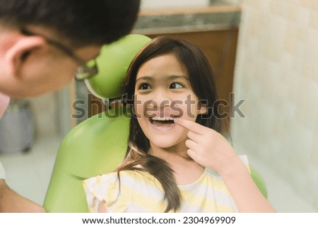 Cute Asain girl during dental treatment at modern clinic
