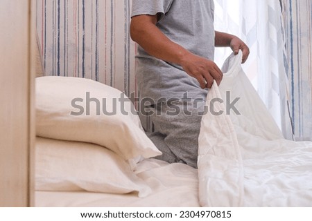 Cropped image of a man go to bed prepare to sleep with white blanket