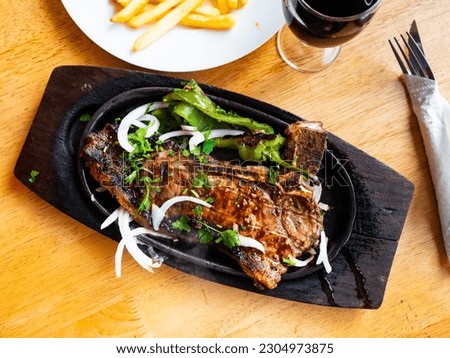 Medium roast entrecote garnished with salad of fresh vegetables, decorated with cottage cheese Royalty-Free Stock Photo #2304973875