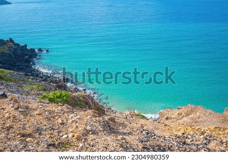 Aerial view of sea waves and fantastic Rocky coast, Beautiful clear underwater surface. Sea rocky bottom under transparent blue water. Clear turquoise sea surface rippled with sun ray reflection.
