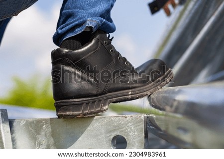 Wear safety shoes to ensure safety at work. construction workers wear safety shoes. People with factory safety concept Royalty-Free Stock Photo #2304983961