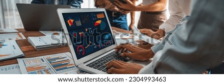 Panorama shot analyst team utilizing BI Fintech to analyze financial report with laptop. Businesspeople analyzing BI power dashboard displayed on laptop screen for business insight. Scrutinize Royalty-Free Stock Photo #2304993463
