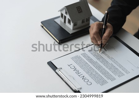 Reading the details and signing the house purchase contract Businessman, investor, insurance agent, investment analysis. Home loan. Real estate business concept.