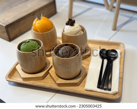 Ice cream Homemade in Thailand, Variety of ice cream flavors in wooden cup blueberry, strawberry, mango, almond, orange and cherry mounted on white wooden background.Summer and sweet menu concept.