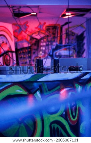 Abandoned empty place with pink and purple lights, urban ghetto showing artistic spray paint under fluorescent neon lights. Deserted old neglected building being illuminated. Royalty-Free Stock Photo #2305007131