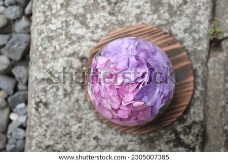 Pink and purple hydrangeas floating in a round vase