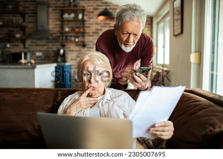 Close up of a Senior couple going over their bills in a living room Royalty-Free Stock Photo #2305007695