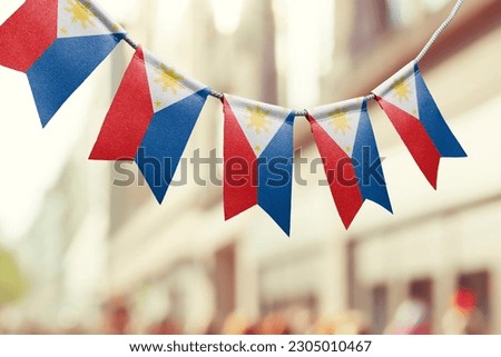 A garland of Philippines national flags on an abstract blurred background.