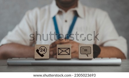 Contact Us symbols on wooden blocks placed on a keyboard in front of staff. Contact Methods. Customer service call center contact us concept