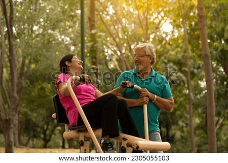 happy senior citizen couple doing exercise in park Royalty-Free Stock Photo #2305055103
