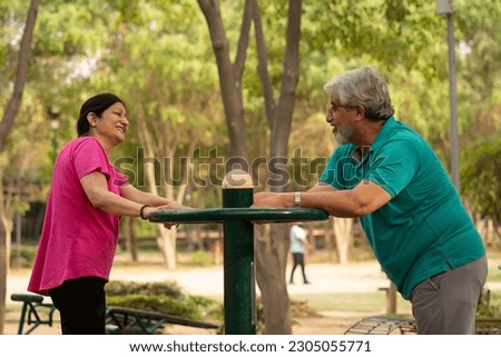 Happy senior citizen couple doing exercise in park Royalty-Free Stock Photo #2305055771
