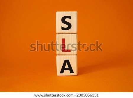 SLA - Service Level Agreement. Wooden cubes with word SLA. Beautiful orange background. Business and Service Level Agreement concept. Copy space.