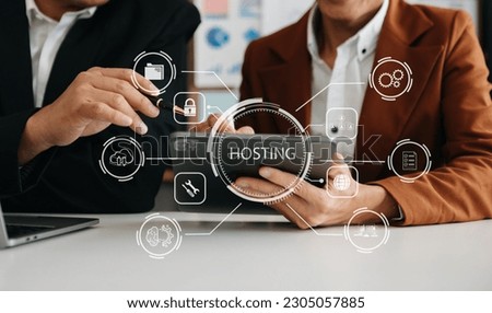 Web hosting concept, man and woman using computer laptop, tablet and presses his finger on the virtual screen inscription Hosting on desk, Internet, business, digital technology concept.
