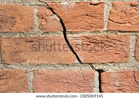 Dangerous old exposed brick wall with deep crack due to structural foundation failure, soil subsidence, corrosion and deterioration of building materials, Climate and seasonal changes, earthquake  Royalty-Free Stock Photo #2305069145