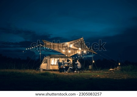 Asian LGBTQ+ couple drinking and barbecue in a romantic camping setting. Groups of friends and couples having a drink party in a camping atmosphere amidst forests and rivers. Royalty-Free Stock Photo #2305083257