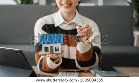 Asian woman gives the house keys to the client after signing a real  contract and tenant, home insurance.