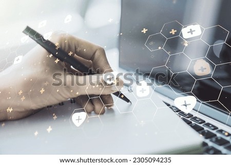 Creative concept of abstract medical illustration and hand writing in notebook on background with laptop. Medicine and healthcare concept. Multiexposure
