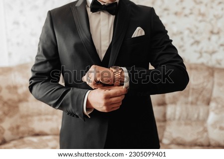 cropped photo of a stylish man adjusting his jacket. Front view. A stylish watch. Men's style. Fashion. Business