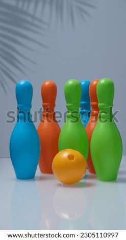 Bowling pins .Childrens plastic set on the white mirror surface..