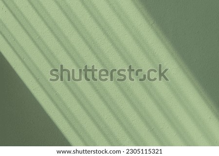 Light Shining Through Glass Louvers Window On The Green Pastel Color Wall Pattern Background, Soft Light Pattern On The Green Pastel Color Wall, Sun Shining Through Window Blinds Royalty-Free Stock Photo #2305115321
