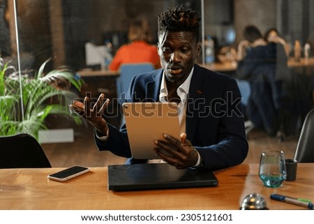 Portrait of successful businessman in office. Handsome businessman using digital tablet.