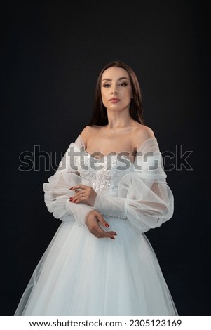 Beautiful fashion bride in wedding dress posing on black background