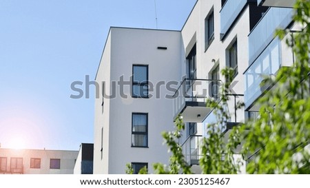 Eco architecture. Green tree and new residential building. Harmony of nature and modernity. Modern apartment building with new apartments in a green residential area. Royalty-Free Stock Photo #2305125467