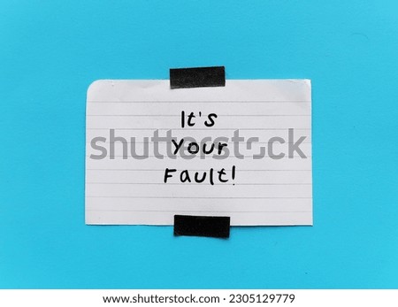 stick note on blue background with handwriting IT'S YOUR FAULT, means gaslighting or to accuse or emotional abuse others to question your beliefs and perception of reality Royalty-Free Stock Photo #2305129779