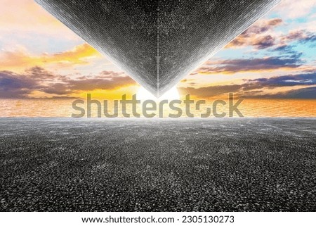 Asphalt pavement concrete geometric shape building with sunset views of the sea