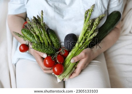 woman girl lying on bed holding in arms vegetables like asparagus,tomatoes,cucumbers,avocado and zucchini.lose weight concept,fat on belly abdoment,healthy nutrition,fibers Royalty-Free Stock Photo #2305133103